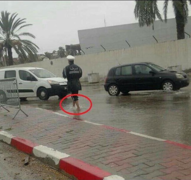 صورة اليوم في صفاقس : عون مرور حافي القدمين وتحت الأمطار الغزيرة