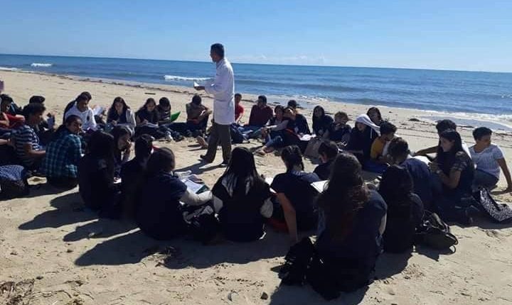 استاذ يدرس تلاميذه على شاطي البحر